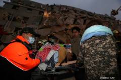 หน่วยกู้ภัยค้นหาผู้ที่ติดอยู่ใต้ซากตึกในเมืองไถหนานที่ถล่มลงมาจากเหตุแผ่นดินไหวขนาด 6.4 
