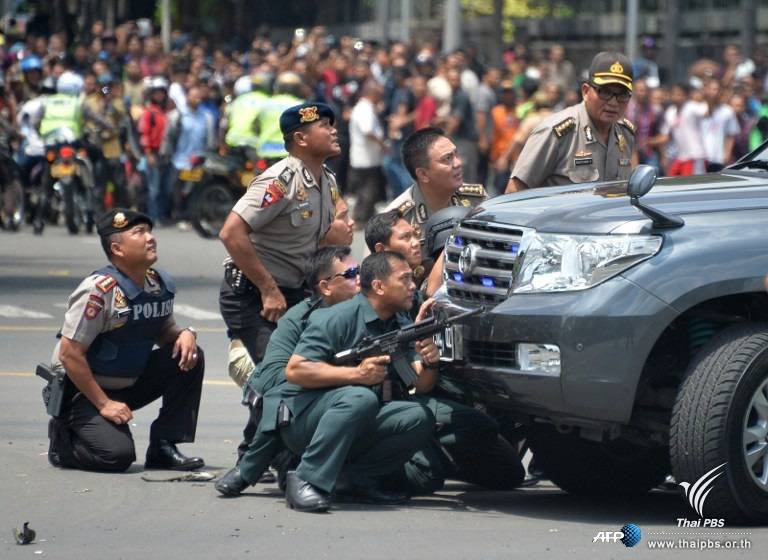 เจ้าหน้าที่หลบหลังรถยนต์ที่จอดอยู่กลางถนนระหว่างไล่ล่าผู้ต้องสงสัยก่อเหตุระเบิดหลายจุดในกรุงจาการ์ตา อินโดนีเซีย
