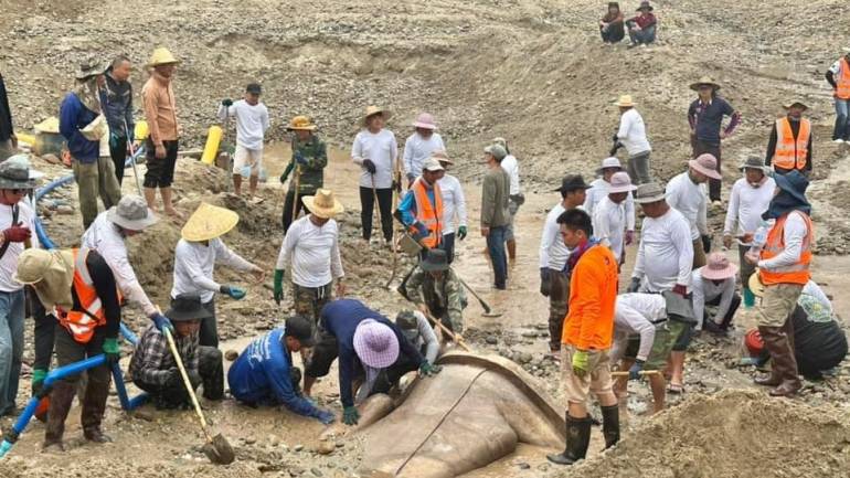 ชาวบ้านกำลังช่วยกันขุด พระพุทธรูปที่คาดว่าเป็นพระประธานวัดโบราณแห่งหนึ่งริมแม่น้ำโขง ในประเทศลาว อายุราว 500-600 ปี