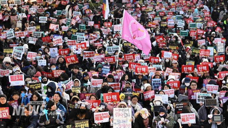 บรรยากาศการชุมนุมบริเวณใกล้อาคารรัฐสภา ในกรุงโซล ของเกาหลีใต้ เพื่อขับไล่ประธานาธิบดี ยุน ซอก ยอล ออกจากตำแหน่งเมื่อคืนที่ผ่านมา (13 ธ.ค.67) เป็นไปด้วยความครึกครื้น