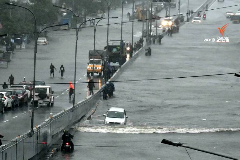 ประชาชนเดินบนถนนที่ถูกน้ำท่วมหลังฝนตกหนักในเมืองเจนไน เมื่อวันที่ 4 ธ.ค.2566 จากอิทธิพลพายุไซโคลนมีชอง