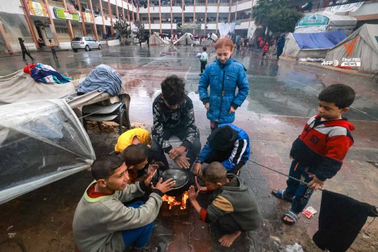 ผู้ลี้ภัยในกาซา พยายามก่อกองไฟให้ความอบอุ่นเมื่อฝนตก