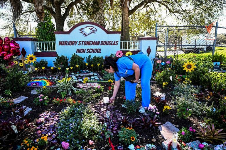 ผู้คนวางดอกไม้ไว้อาลัยเหตุการณ์กราดยิงในโรงเรียนมัธยมมาร์จอรีย์ สโตนแมน ดักลาส