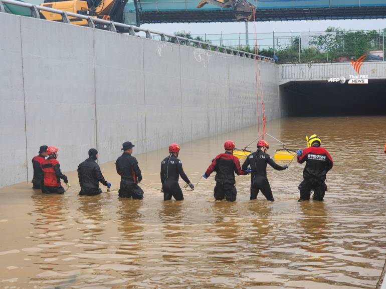 กู้ภัยเกาหลีใต้ค้นหาผู้สูญหายใกล้กับรถบัส บนถนนที่มีน้ำท่วมซึ่งนำไปสู่อุโมงค์ใต้ดิน